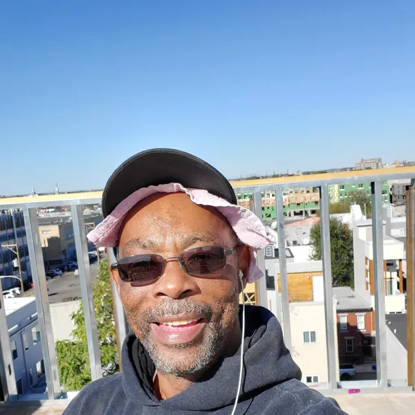 Anthony Wood of A.V. Electric on a rooftop with the Philadelphia skyline behind him